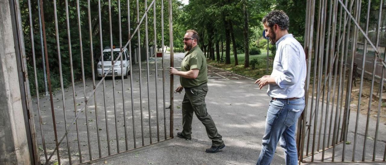 El concejal, Andrés Licerán, y el guarda del parque, abren la puerta del recinto, ya libre de jabalíes.