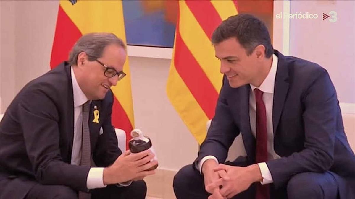 Quim Torra muestra la botella de ratafía a Pedro Sánchez, el lunes en la Moncloa.