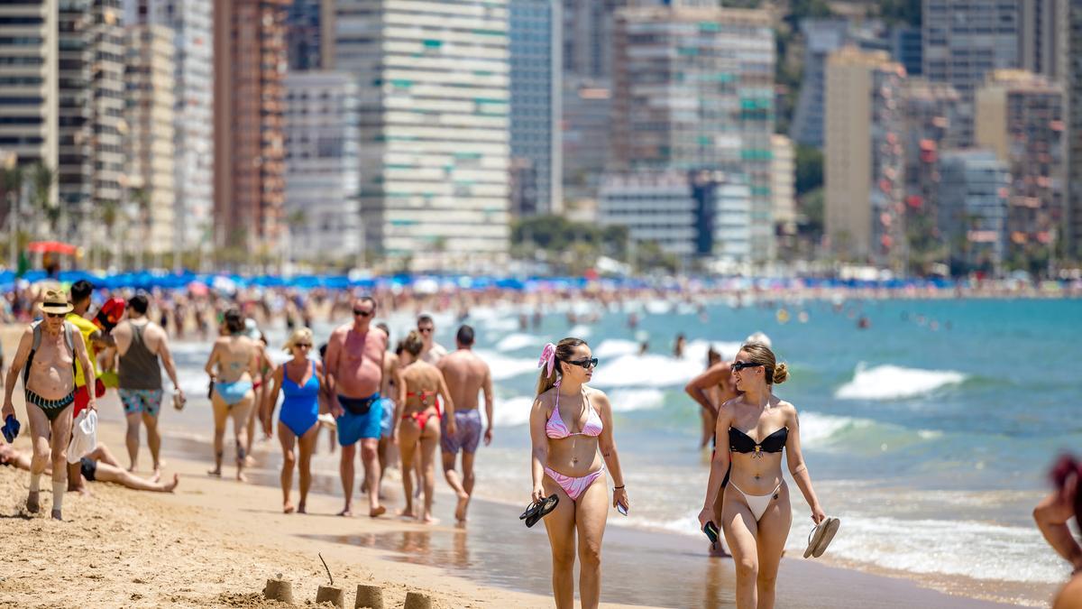 Bañistas caminando por la playa en Benidorm.