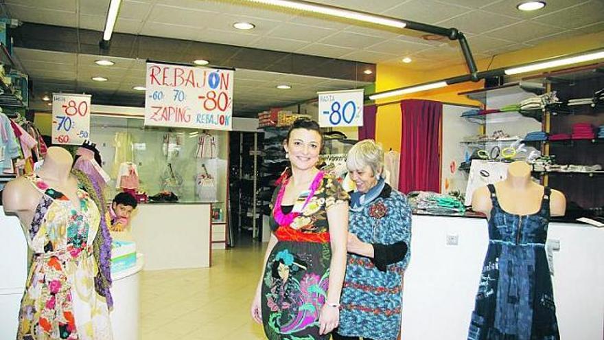 Marcolina García, dueña de una tienda en Blimea, atiende a una clienta.