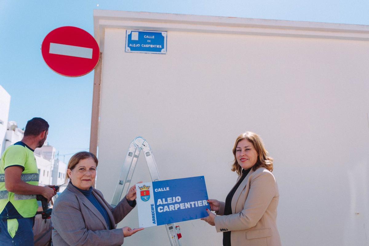 Ángela Hernández (izquierda) y Astrid Pérez, con una de las nuevas placas de calles de Arrecife, en el barrio de Argana Alta.