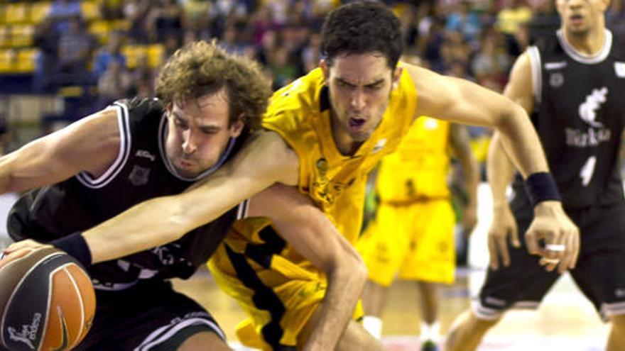 El alero del Gran Canaria 2014, Javier Beiran (c), y el escolta del Bizkaia Bilbao Basket, Roger Grimau (i), luchan por un balón durante el partido correspondiente a la séptima jornada de la Liga ACB que ambos equipos disputan hoy en el Centro Insular de Deportes de la capital grancanaria.