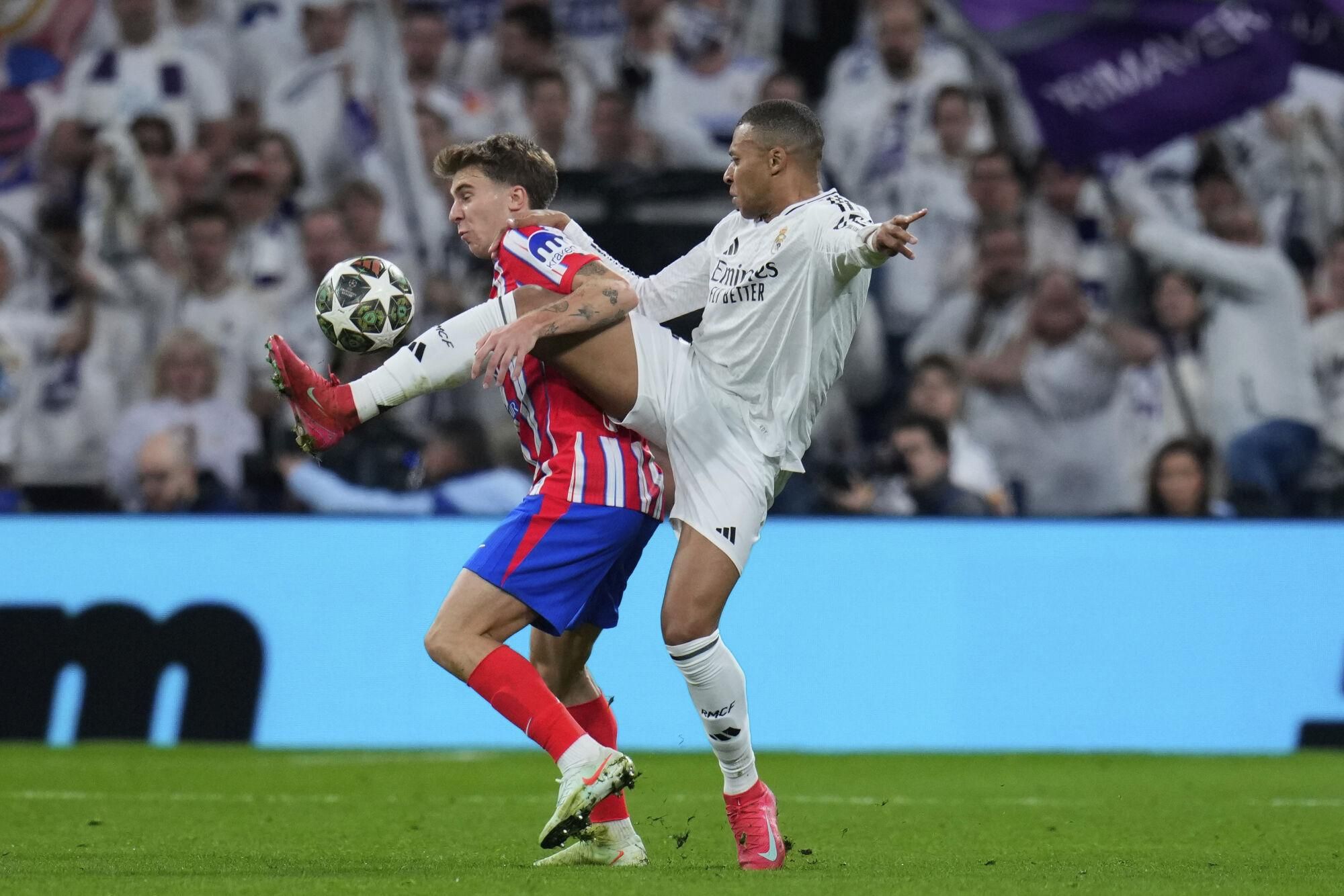 Atletico Madrid's Pablo Barrios, left, fights for the ball with Real Madrid's Kylian Mbappe during the Champions League round of 16 first leg soccer match between Real Madrid and Atletico Madrid at the Bernebeu stadium in Madrid, Spain, Tuesday, March 4, 2025. (AP Photo/Manu Fernandez). EDITORIAL USE ONLY / ONLY ITALY AND SPAIN
