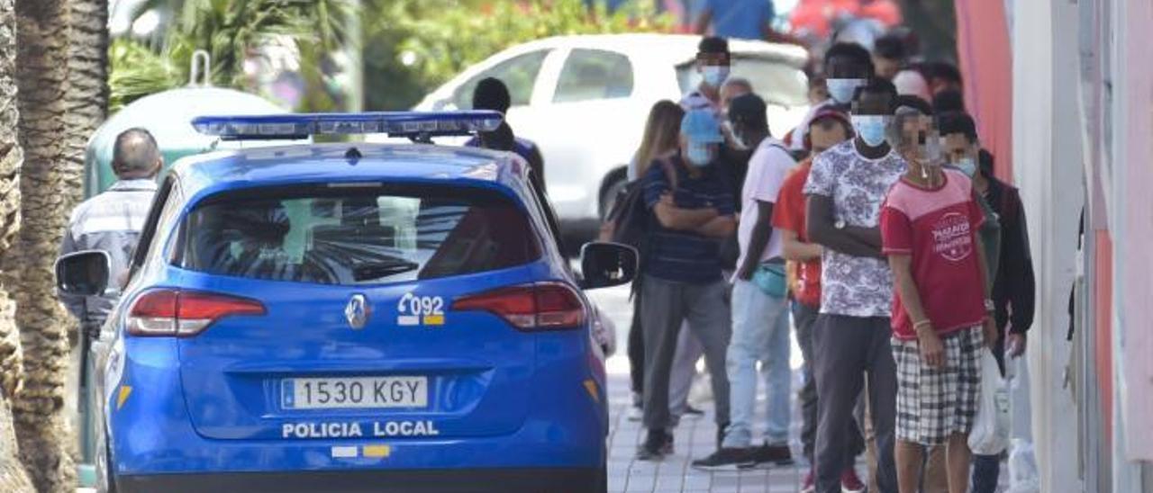 Cola de personas esperan para recibir comida a las puertas de Cáritas. |