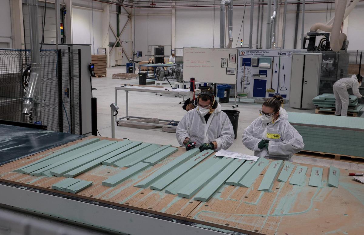 Operarios de InCom, con varias de las piezas que fabrica la empresa.