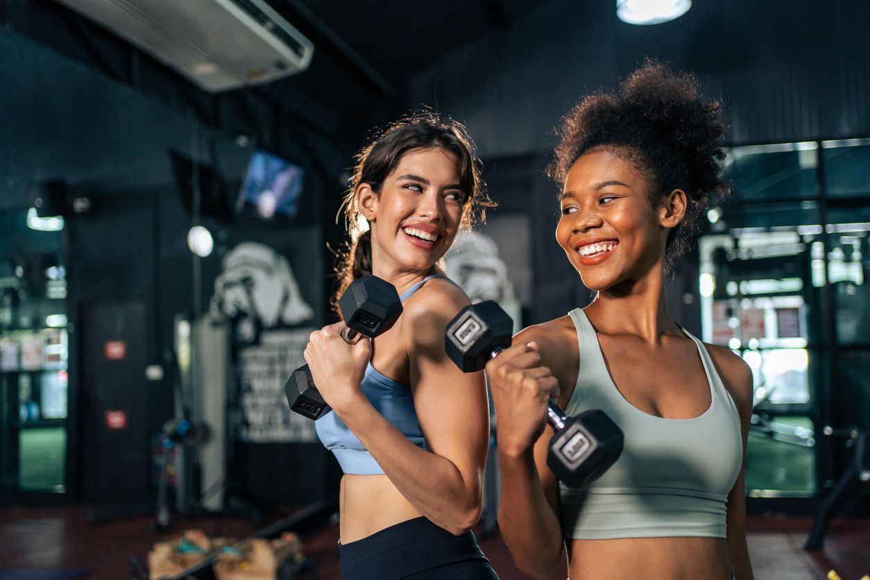Mujeres realizando ejercicios con mancuernas en el gym