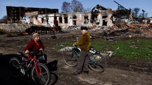 Civiles entre edificios en ruinas, según los residentes destruídos por bombardeos aéreos durante la invasión rusa de Ucrania, en Trostianets, región de Sumy.