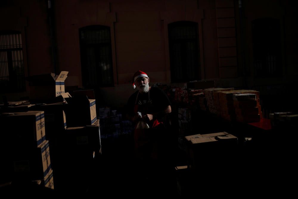 A volunteer prepares to distribute food to ...