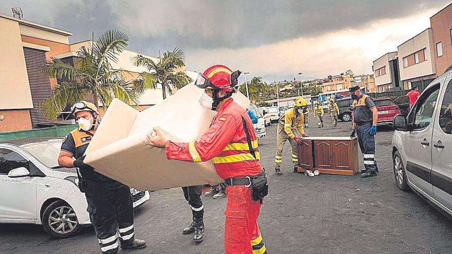 Habitantes desalojados del barrio de La Laguna, el pasado martes, que abandonan sus casas escoltados por las fuerzas de seguridad.