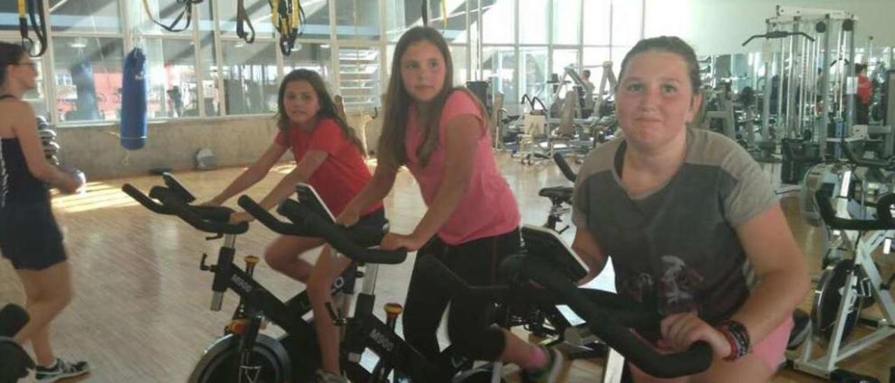 Tres niñas practican spinning en una clase de &quot;cardio kids&quot; , en el pabellón de Baiona.