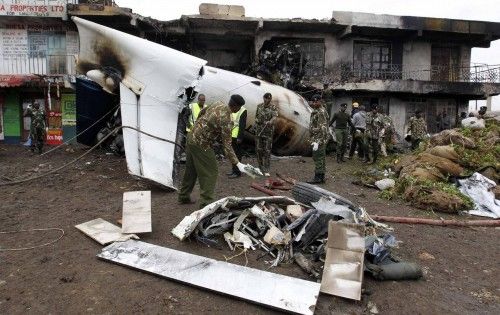 El personal de seguridad intenta recuperar cadáveres de entre los restos de un avión de carga que se estrelló en un edificio comercial en la finca Utawala, en las afueras de la capital de Kenia Nairobi.
