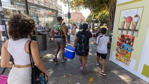 Una familia sale de la estación de Alicante cargando una nevera.