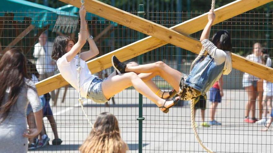 Dos participantes, escalando por una cuerda ayer, durante las actividades de la feria juvenil de La Arena.