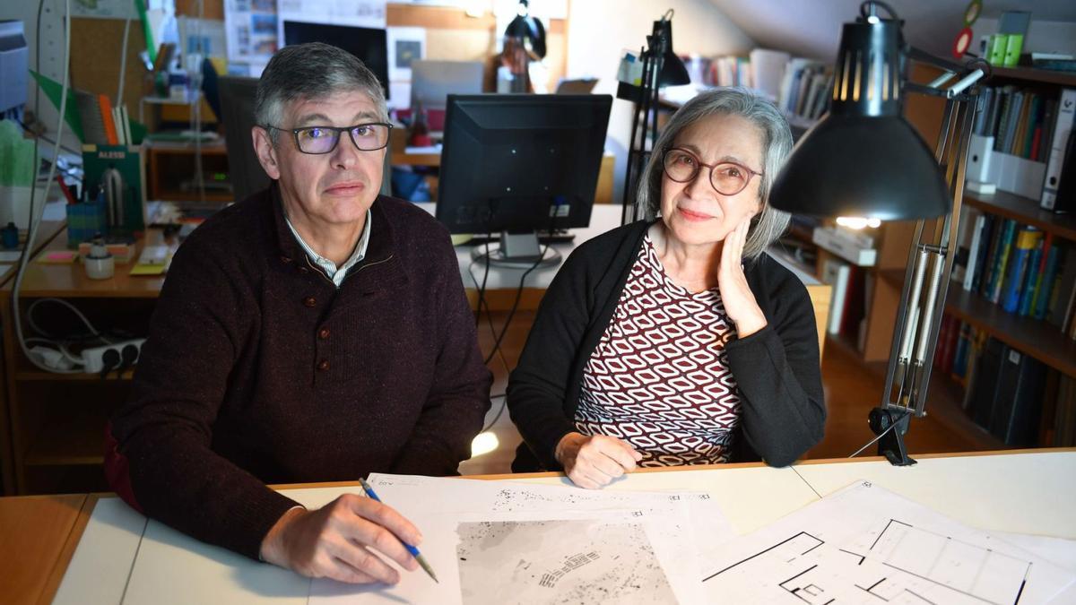 Cándido López y María Carreiro, arquitectos que diseñan las granjas sostenibles, en su estudio de A Coruña ante los planos.   | // VÍCTOR ECHAVE