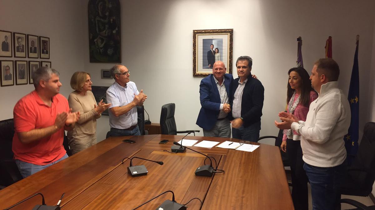 Víctor Martí y Josep Maria Pons se dan la mano tras firmar el nuevo pacto, este lunes en el ayuntamiento de Binissalem.