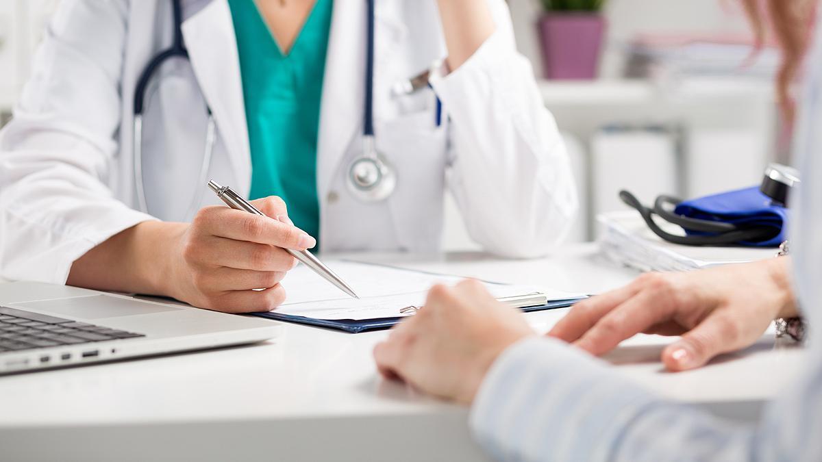 Un médico atiende a una paciente en una consulta.