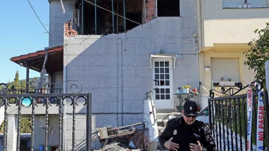 Un policía ante la vivienda donde se produjo la explosión.