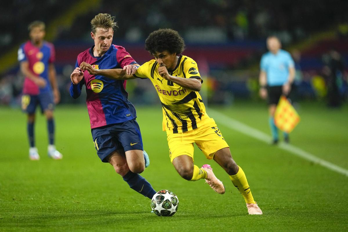 BARCELONA, 09/04/2025.- El delantero del Borussia, Karim Adeyemi (d), intenta llevarse el balón ante el centrocampista neerlandés del FC Barcelona, Frenkie de Jong, durante el encuentro correspondiente a la ida de los cuartos de final de la Liga de Campeones que disputan hoy miércoles FC Barcelona y Borussia Dortmund en el Estadio Olímpico de Montjuic, en Barcelona. EFE / Alejandro García