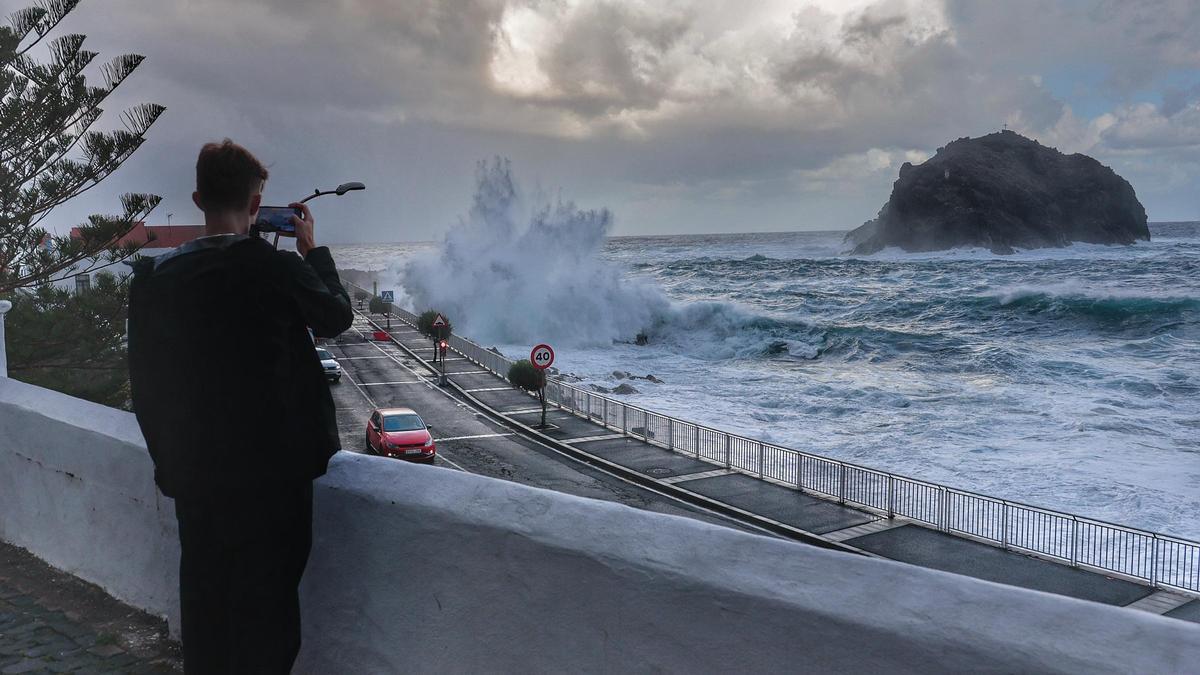 Un hombre saca una foto del oleaje en Garachico.