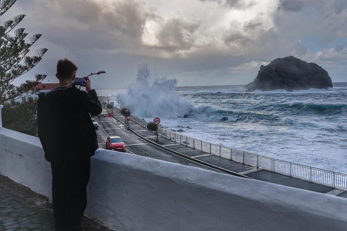 Un hombre saca una foto del oleaje en Garachico.