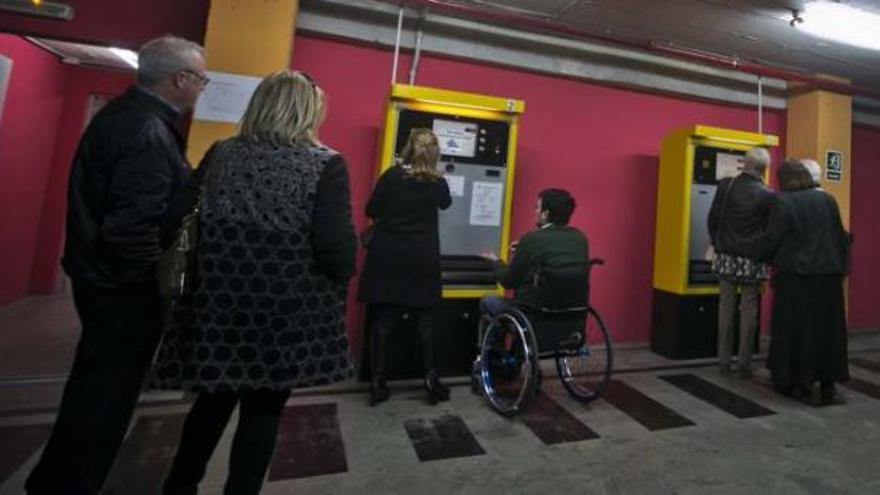 Cola para pagar en el parking y coches aparcados junto a la carretera.