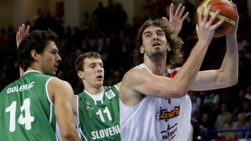 El pívot de la selección española de baloncesto, Pau Gasol (d), intenta el lanzamiento ante los jugadores de la selección de Eslovenia, Jurica Golemac (i), pívot, y Goran Dragic (c), alero, durante el partido del grupo C del Campeonato Europeo de Baloncesto 2009 frente a Eslovenia, esta tarde en el pabellón Torwar, en Varsovia.