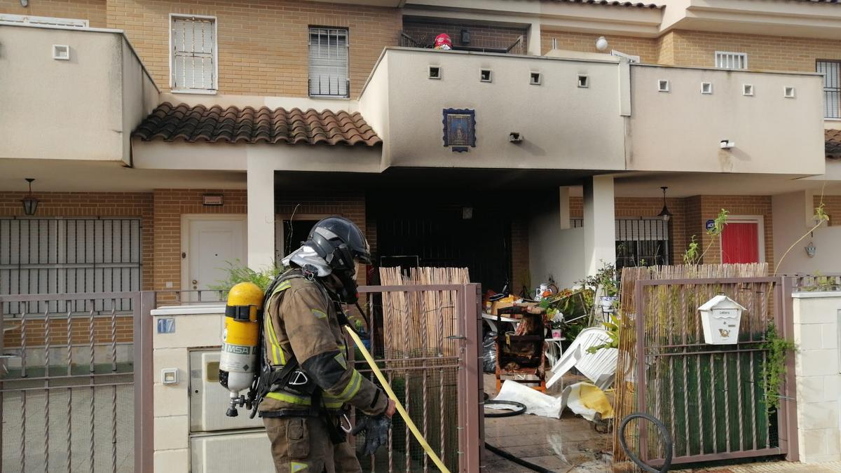 Bomberos trabajan en la vivienda de Los Narejos siniestrada.