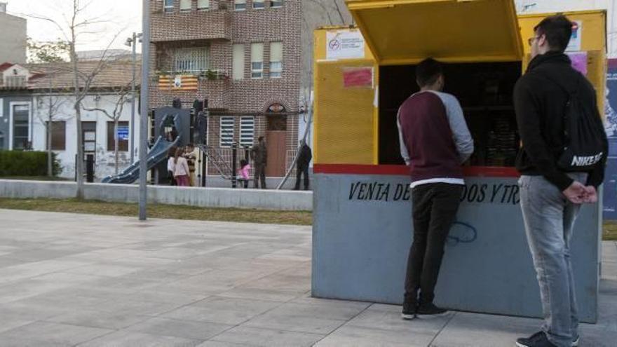 Dos personas compran pirotecnia en la caseta, próxima al parque infantil.