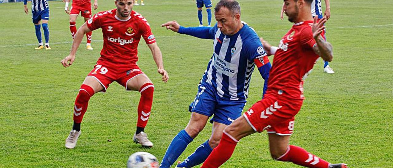 Juli, entre dos rivales, en el choque ante el Nàstic en El Collao.