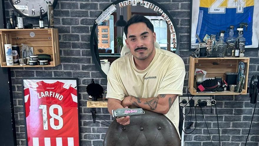 A la izquierda, Luciano Sierra, en su barbería LuchyBarber. Arriba, junto a David Manso, con las  camisetas de los jugadores  | A. M