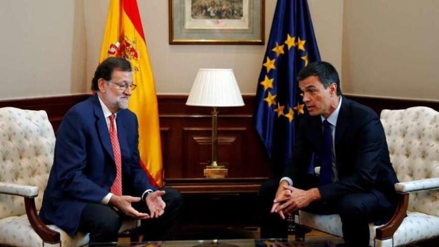 Rajoy y Sánchez cambian las primeras impresiones mientras posan para los medios al inicio de su encuentro. // Efe