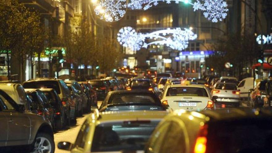 Vehículos en circulación ayer por la calle Juan Flórez, bajo el alumbrado navideño. / juan varela