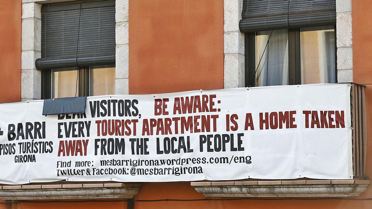 Pancarta de la plataforma +barri -pisos turístics advertint als turistes de la problemàtica que es viu al Barri Vell. | ANIOL RESCLOSA