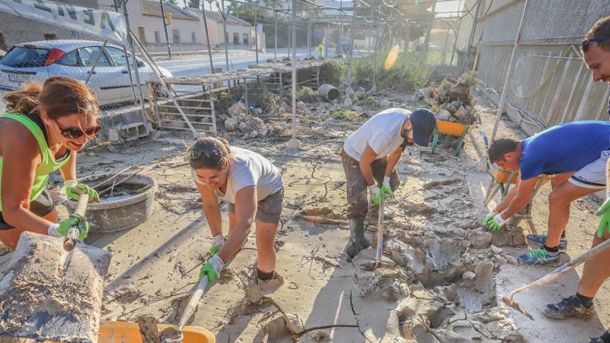 Voluntarios retiran el barro de las calles de Orihuela.