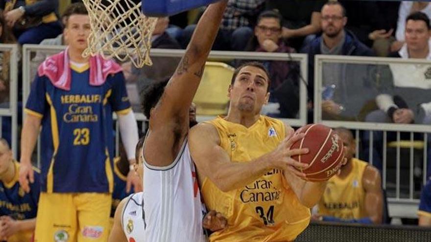 Pablo Aguilar (d), intenta el lanzamiento a canasta ante el alero estadounidense del Real Madrid Trey Tfompkins (i).