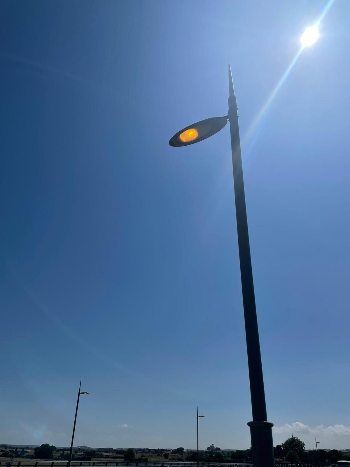 Una farola encendida de día en el puente de los Tres Árboles