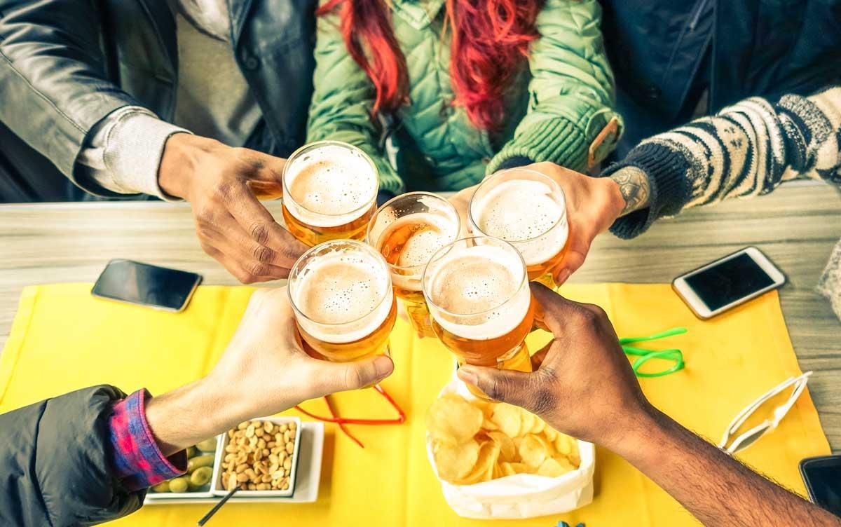 Un grupo de amigos toma unas cervezas en una fiesta.