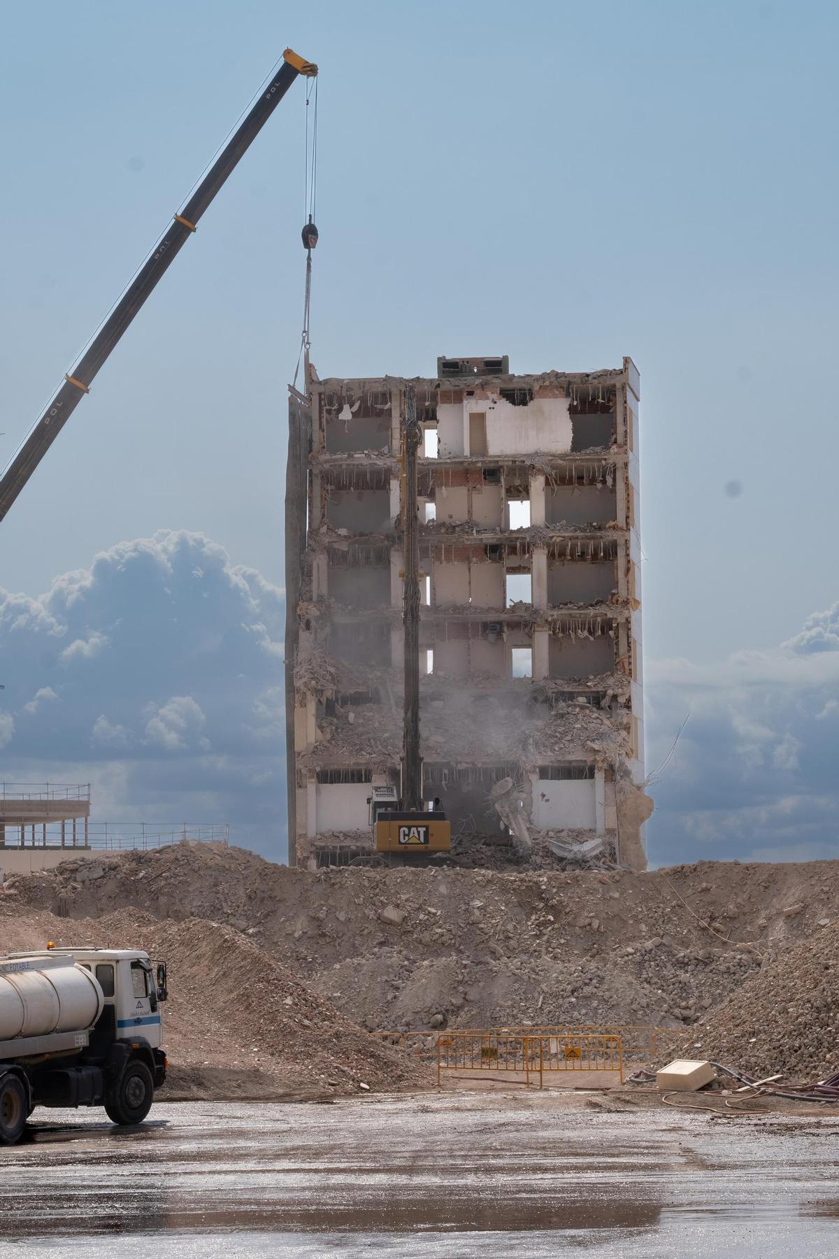 Una grúa derriba este viernes una parte del edificio semicircular ya sin fachada