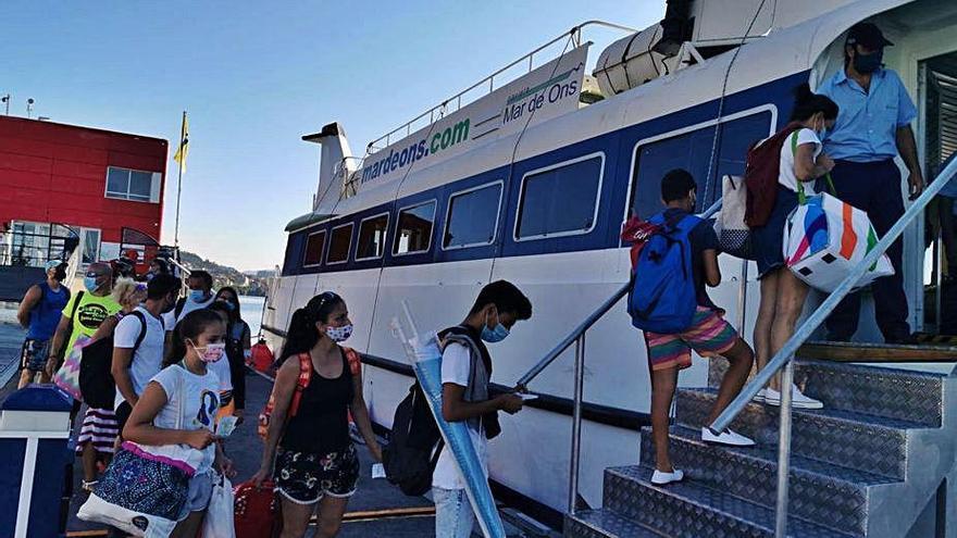 Pasajeros se suben ayer al primer barco de Combarro a Ons.