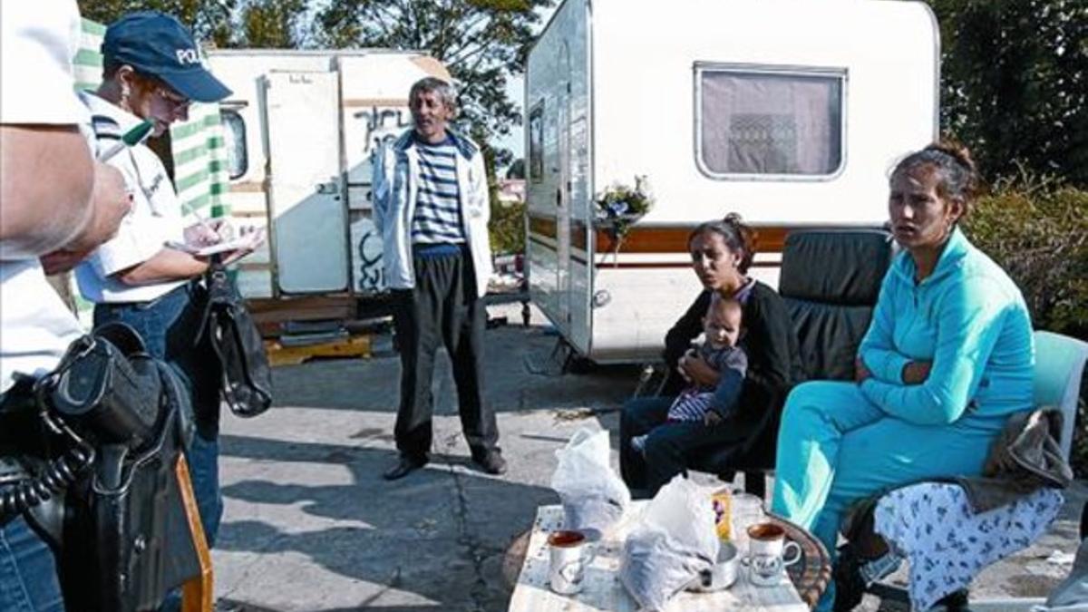 Policías franceses censan a un grupo de gitanos y sus caravanas en un campamento ilegal, cerca de Lille.