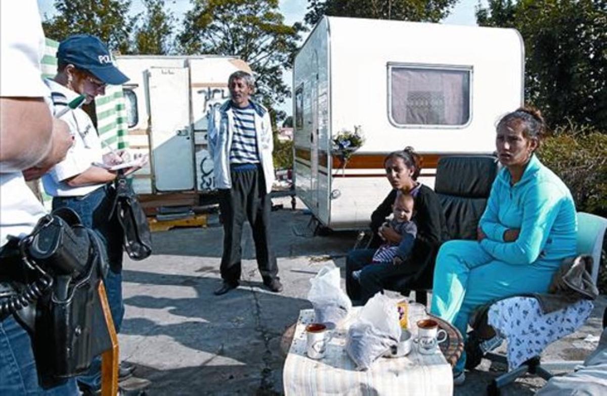 Policías franceses censan a un grupo de gitanos y sus caravanas en un campamento ilegal, cerca de Lille.