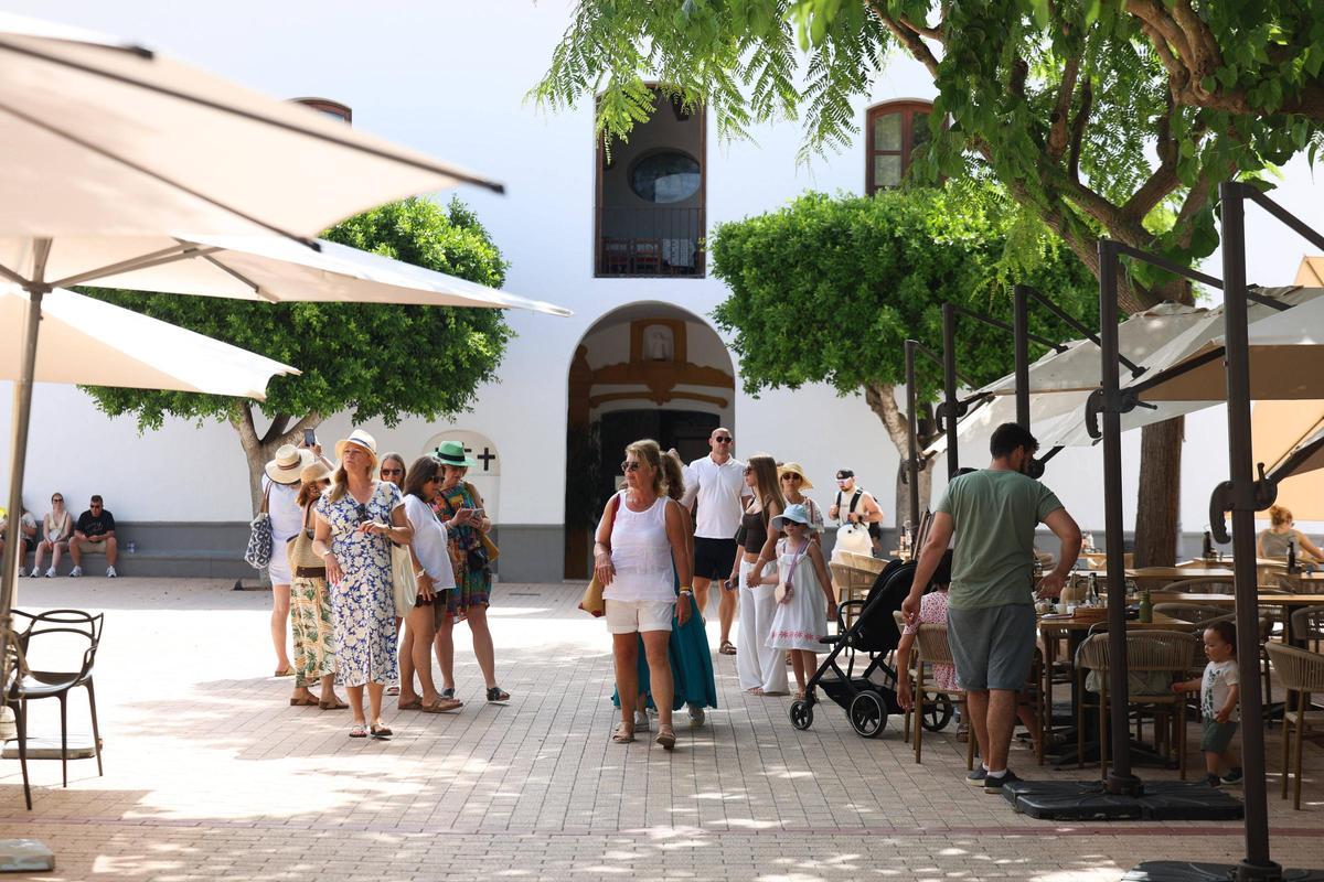 Turistas pasean frente a la plaza de la iglesia de Santa Gertrudis