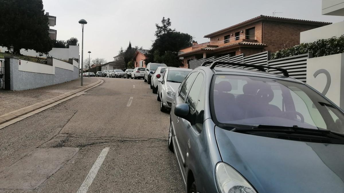 Cotxes mal aparcats ocupant un carril de circulació al barri de Montilivi, prop del campus de la UdG