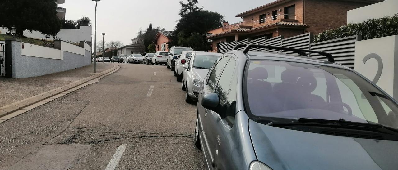 Cotxes mal aparcats ocupant un carril de circulació al barri de Montilivi, prop del campus de la UdG