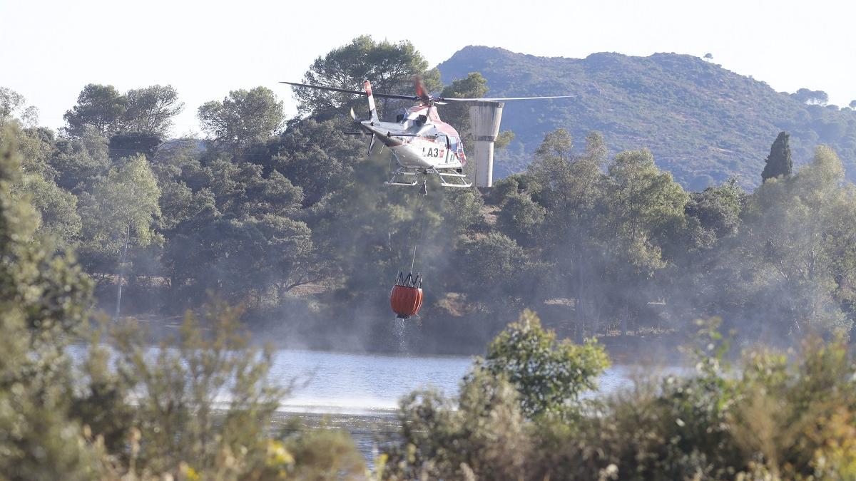 Un helicópero carga agua durante las labores de extinción del incendio de Cerro Muriano.