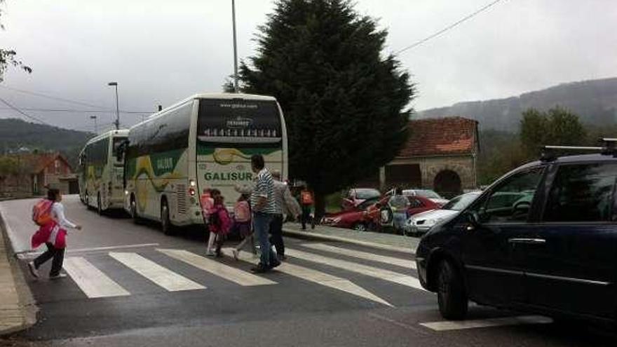 Alumnos del centro cruzan la calle para subirse al autobús . // Faro