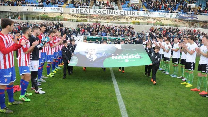 Los jugadores de ambos equipos aplauden al paso de una imagen de Nando Yosu, fallecido el sábado, que portan jóvenes futbolistas del Racing.