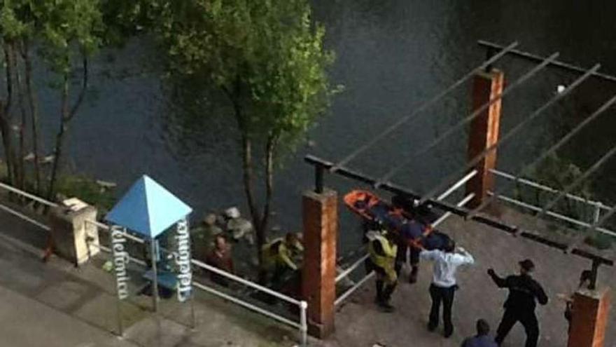 Policía y personal sanitario sacan al hombre de la zona del río.