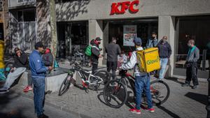 Repartidores de distintas ’apps’ de comida a domicilio esperando a la puerta de un restaurante.