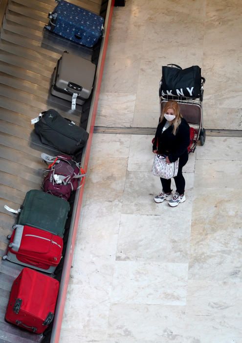 MADRID. 19.03.2020. CORONAVIRUS. Miembros de la UME limpian el aeropuerto de Barajas, terminal T4. En la imagen una mujer espera su maleta. FOTO: JOSE LUIS ROCA